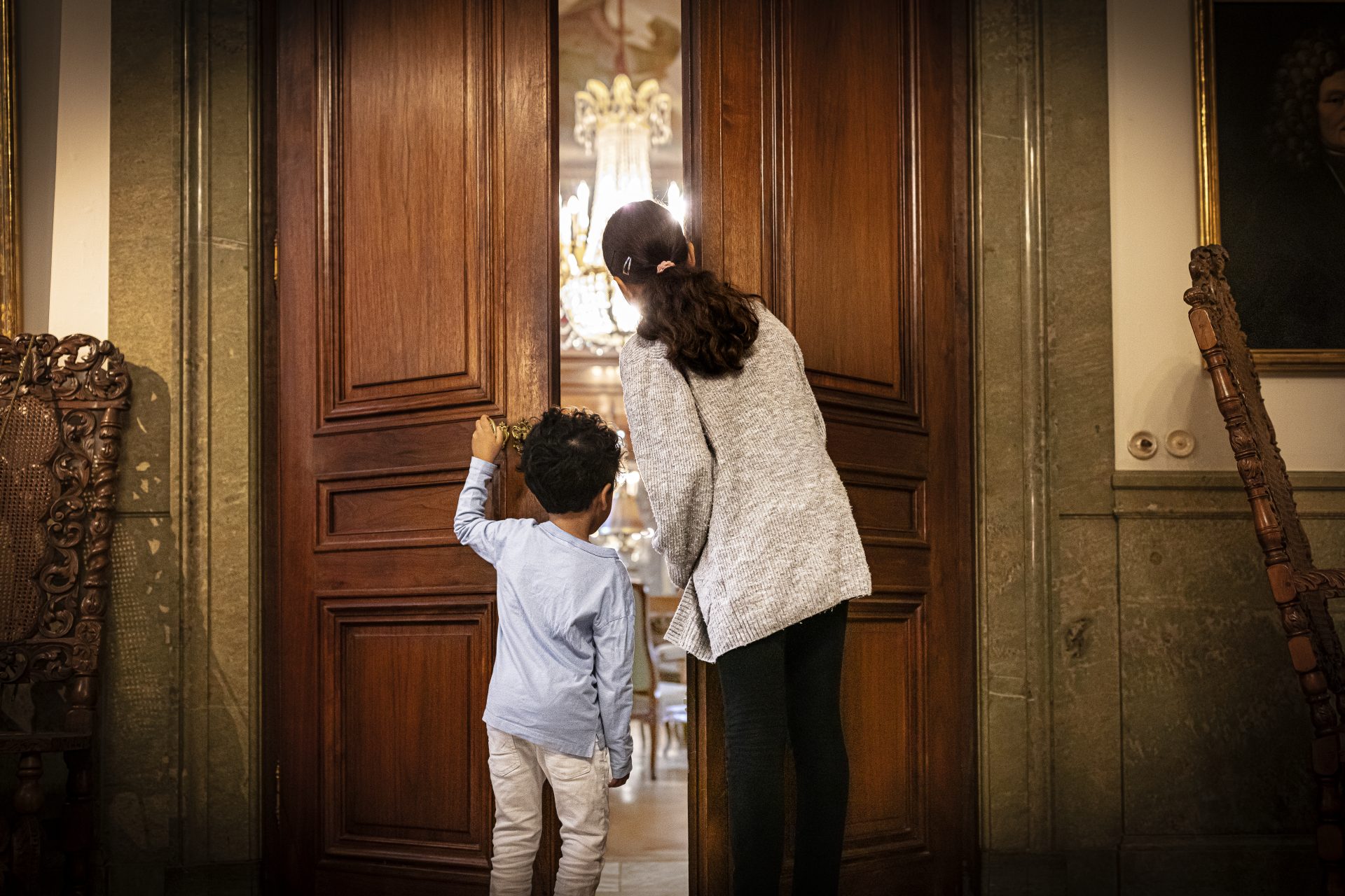  An adult and a child enter a door to the Hallwyl museum.