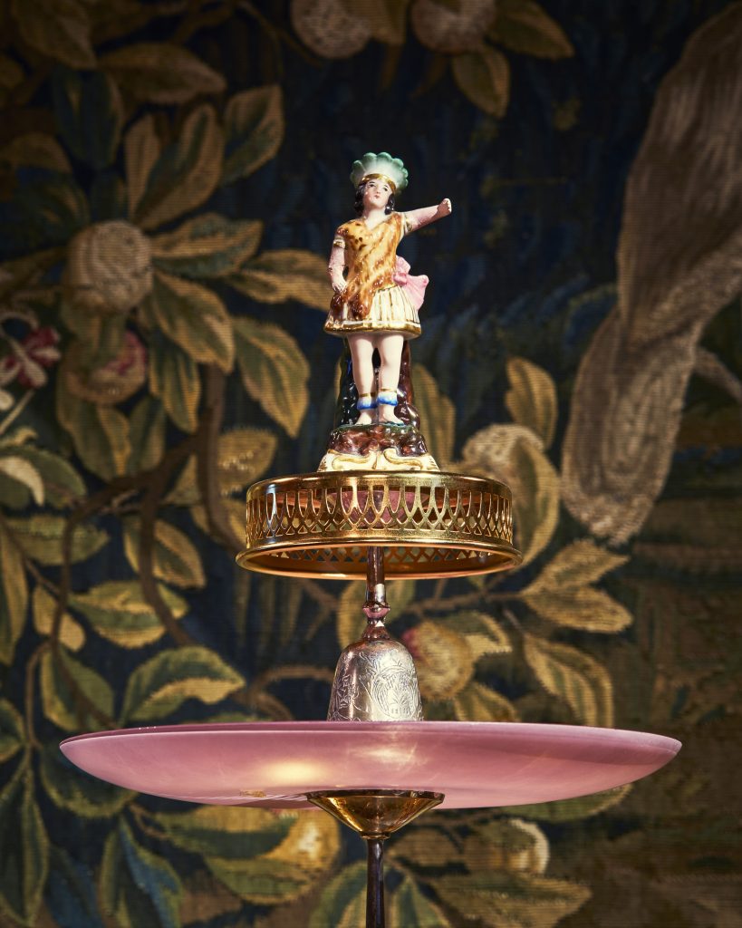 Detaljbild, en figurin i porslin pryder toppen på ett tårtfat med flera våningar