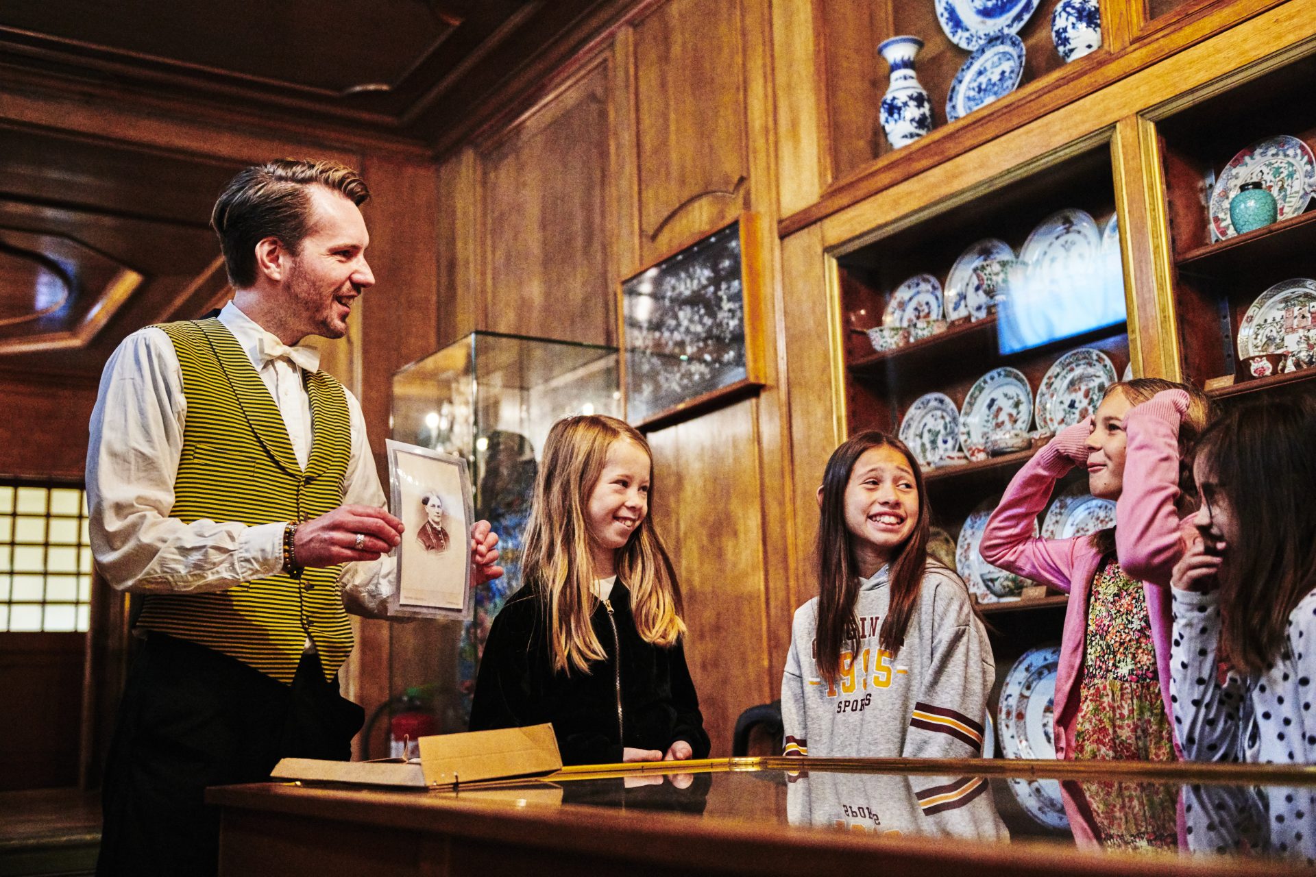 Guide showing young visitors an image of Wilhelmina von Hallwyl