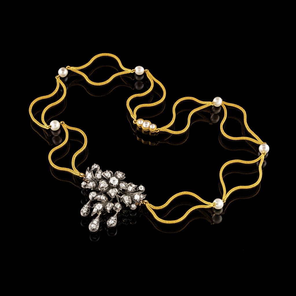 Ett halsband av guld med pärlor och briljanter. 