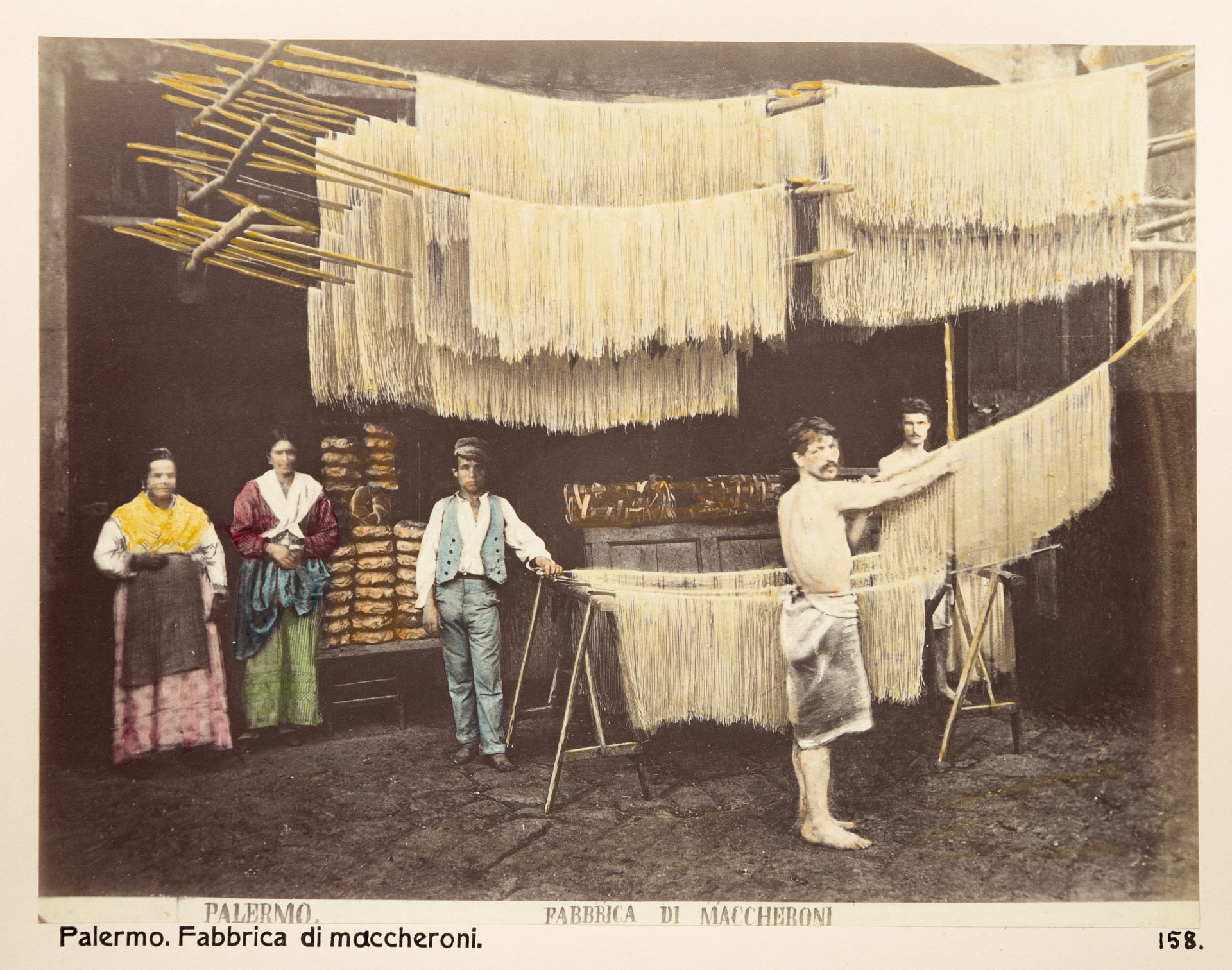 Bild tagen i Sicilien på personer som hänger upp pasta i en pastafabrik.