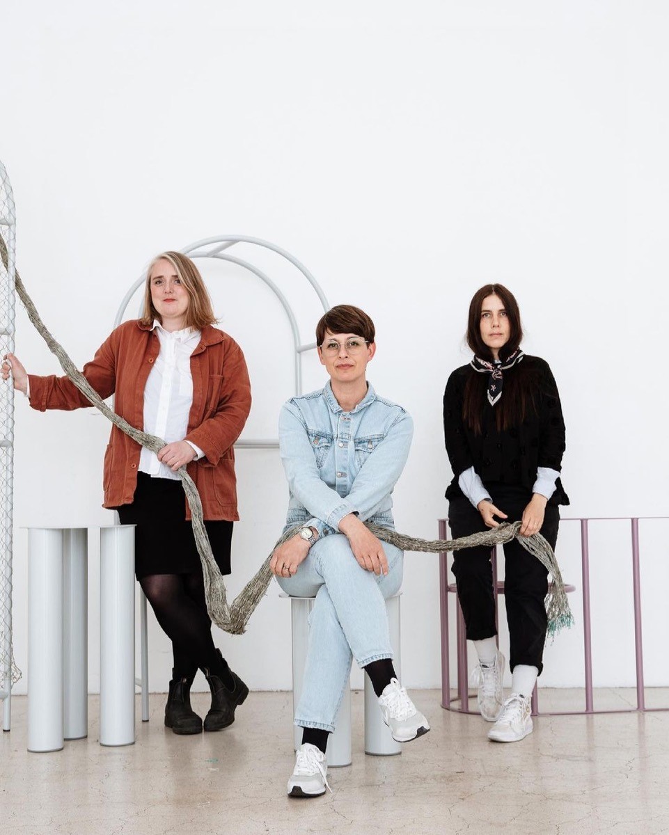 Portrait of the three artists holding a rope