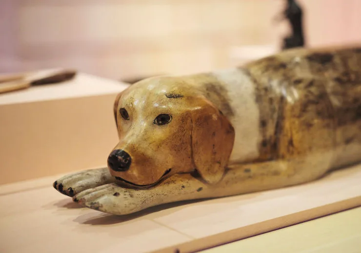 Close-up of a dog carved in wood.