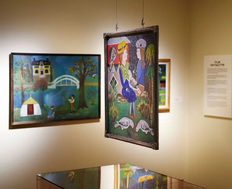 Paintings hanging in the exhibition.